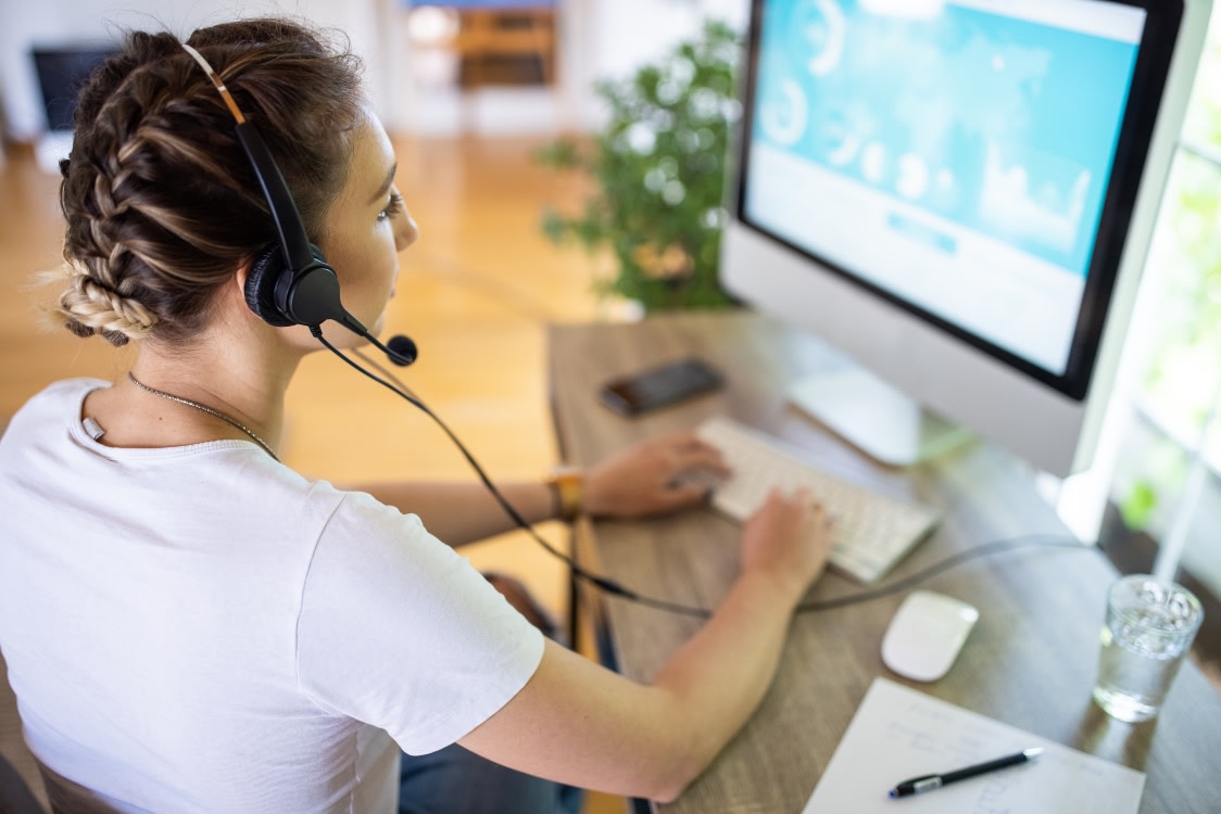 Girl working at a computer with headset on